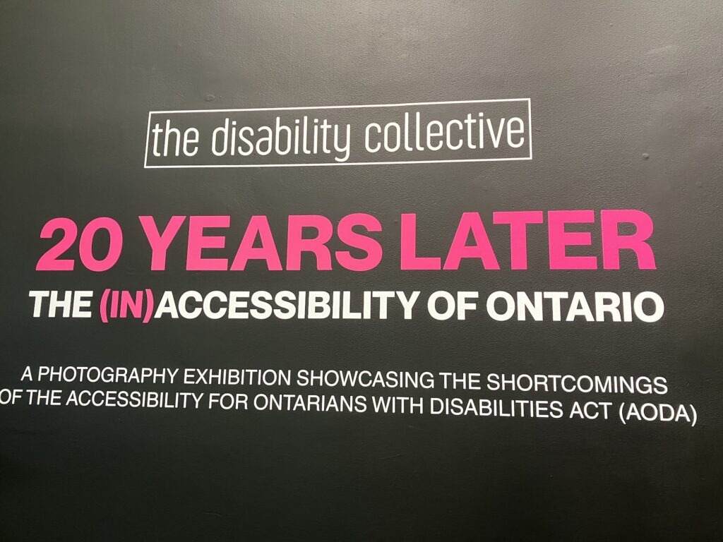 On a black background the logo of The Disability Collective in white, and a text in pink and white saying: 20 years later, the (in)accessibility of Ontario, a photography exhibition showcasing the shortcomings of the accessibility for Ontarians with Disabilities Act (AODA). 20 years later and the text (in) are written in pink, the rest is in white.